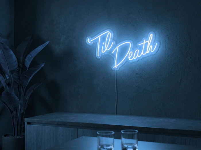 Neonskylt «Til Death» i isblå LED-neon, monterad på vägg