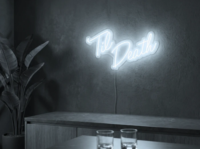 Neonskylt «Til Death» i iskall vit LED-neon, monterad på vägg