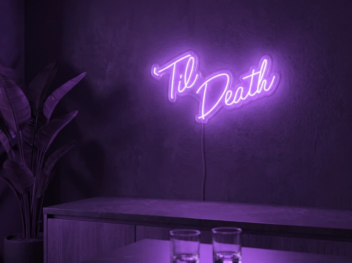 Neonskylt «Til Death» i lila LED-neon, monterad på vägg