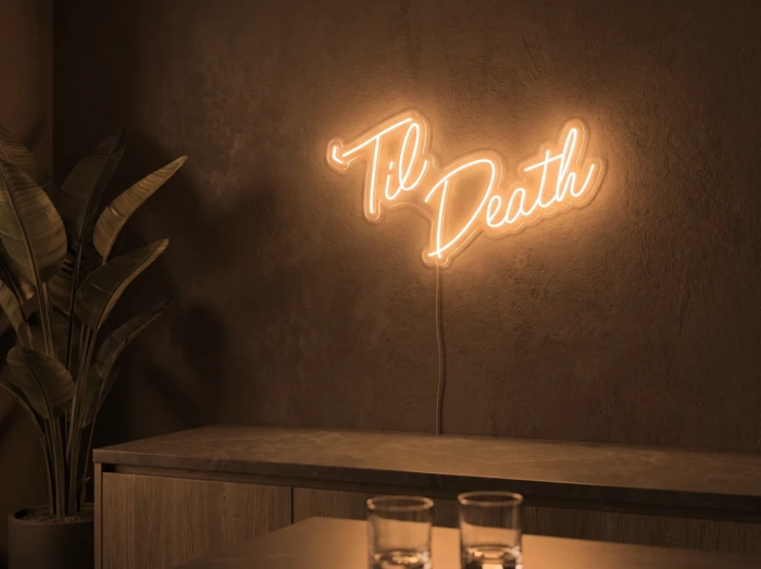 Neonskylt «Til Death» i orange LED-neon, monterad på vägg