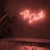 Neonskylt «Til Death» i röd LED-neon, monterad på vägg