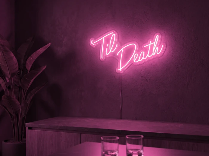 Neonskylt «Til Death» i rosa LED-neon, monterad på vägg