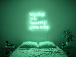 Neonskylt «Together» i mintgrön LED-neon, monterad på vägg
