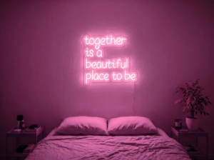Neonskylt «Together» i rosa LED-neon, monterad på vägg