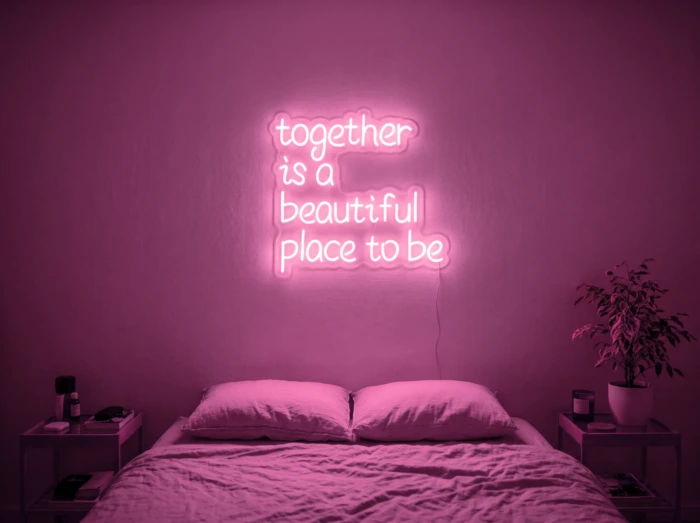 Neonskylt «Together» i rosa LED-neon, monterad på vägg