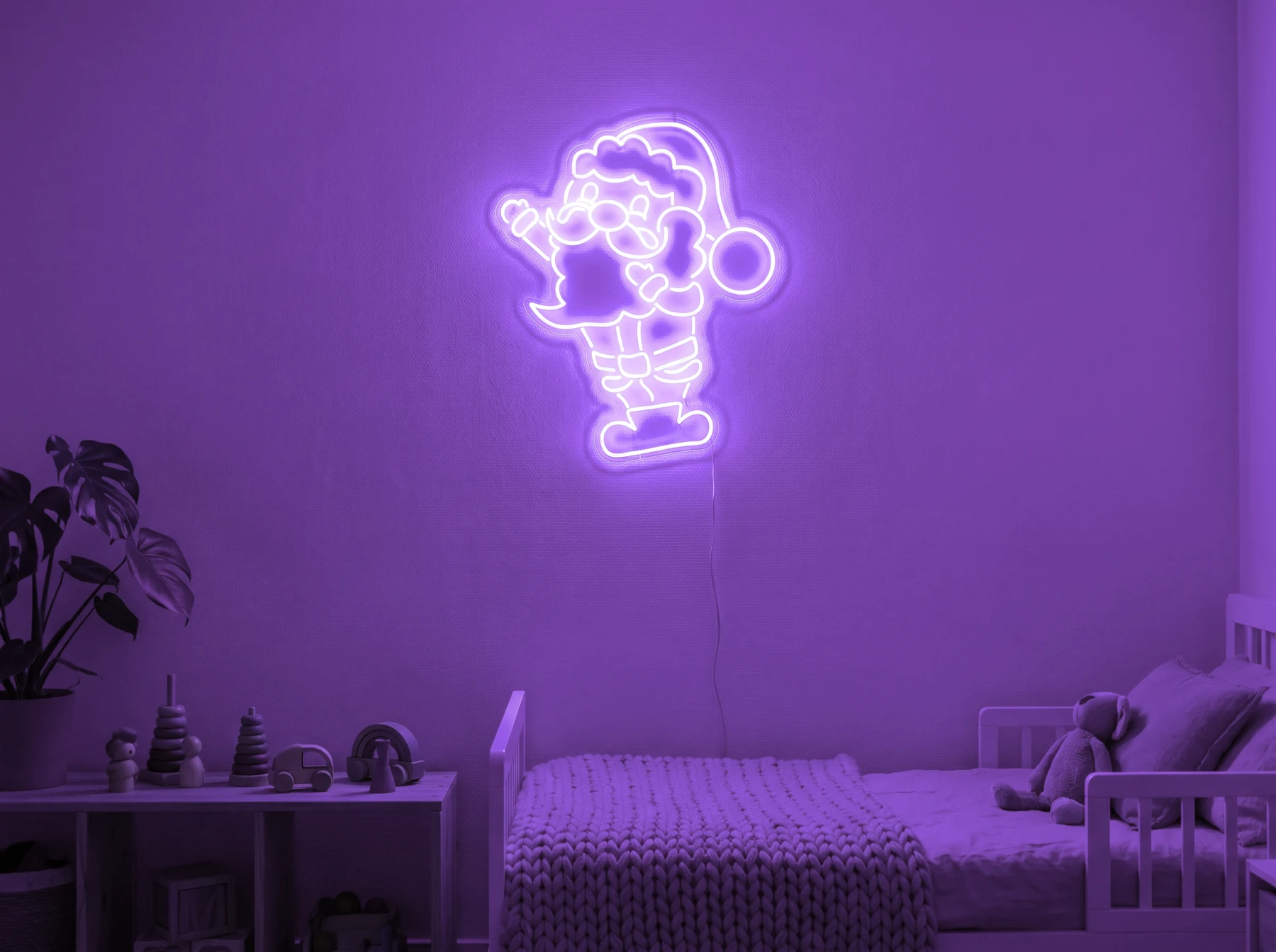 Neonskylt «Tomten» i lila LED-neon, monterad på vägg