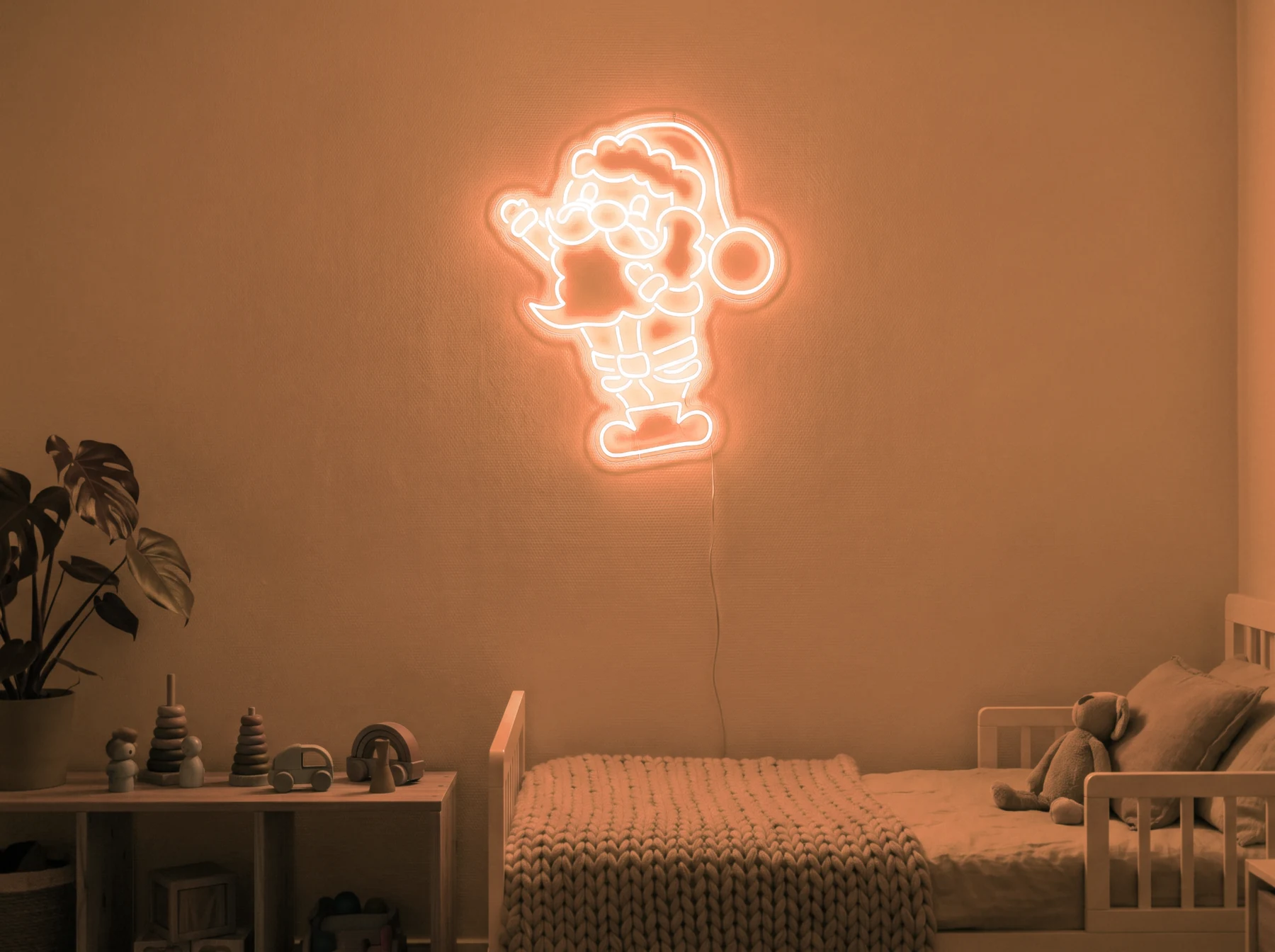 Neonskylt «Tomten» i orange LED-neon, monterad på vägg