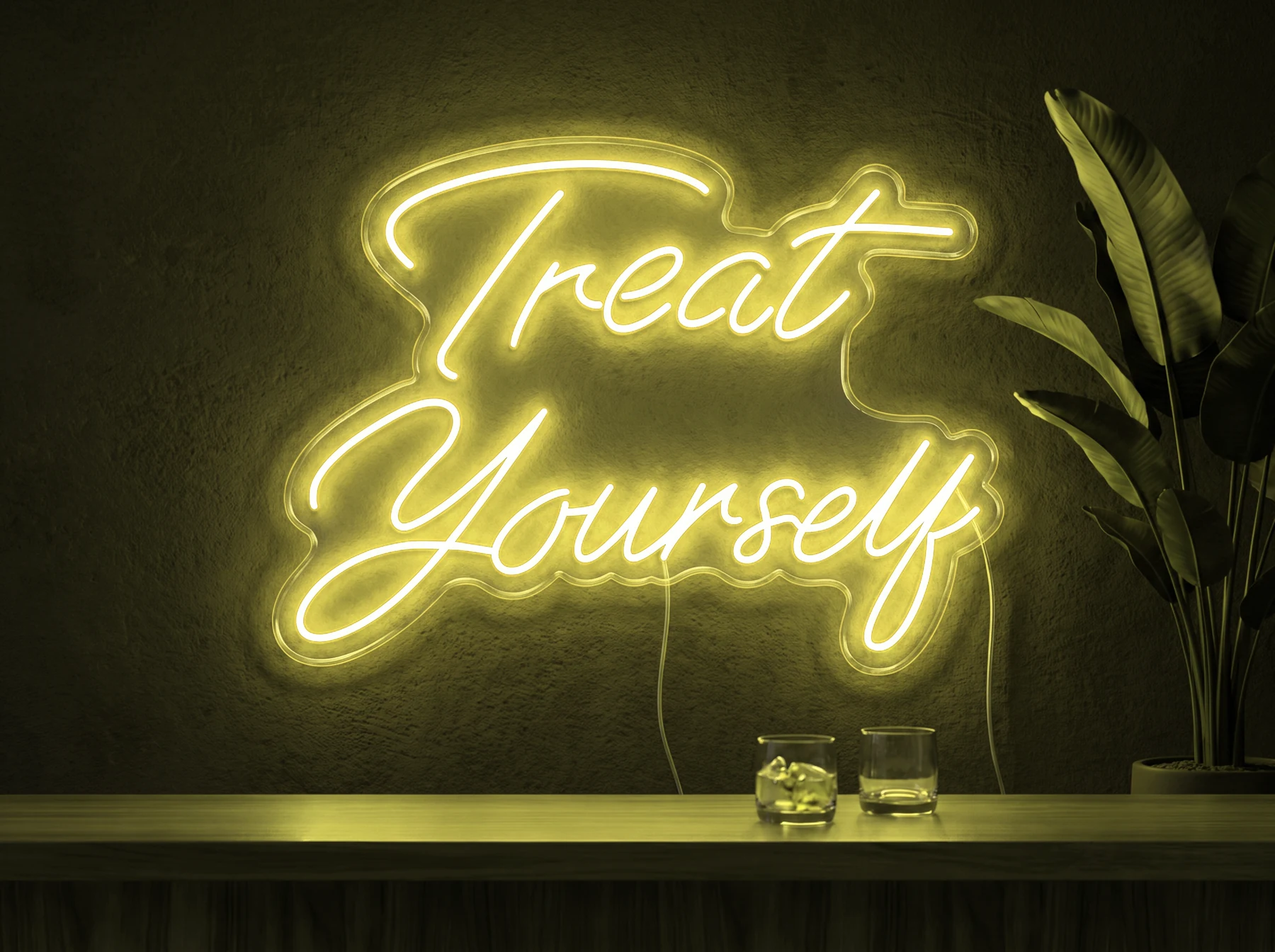 Neonskylt «Treat Yourself» i gul LED-neon, monterad på vägg
