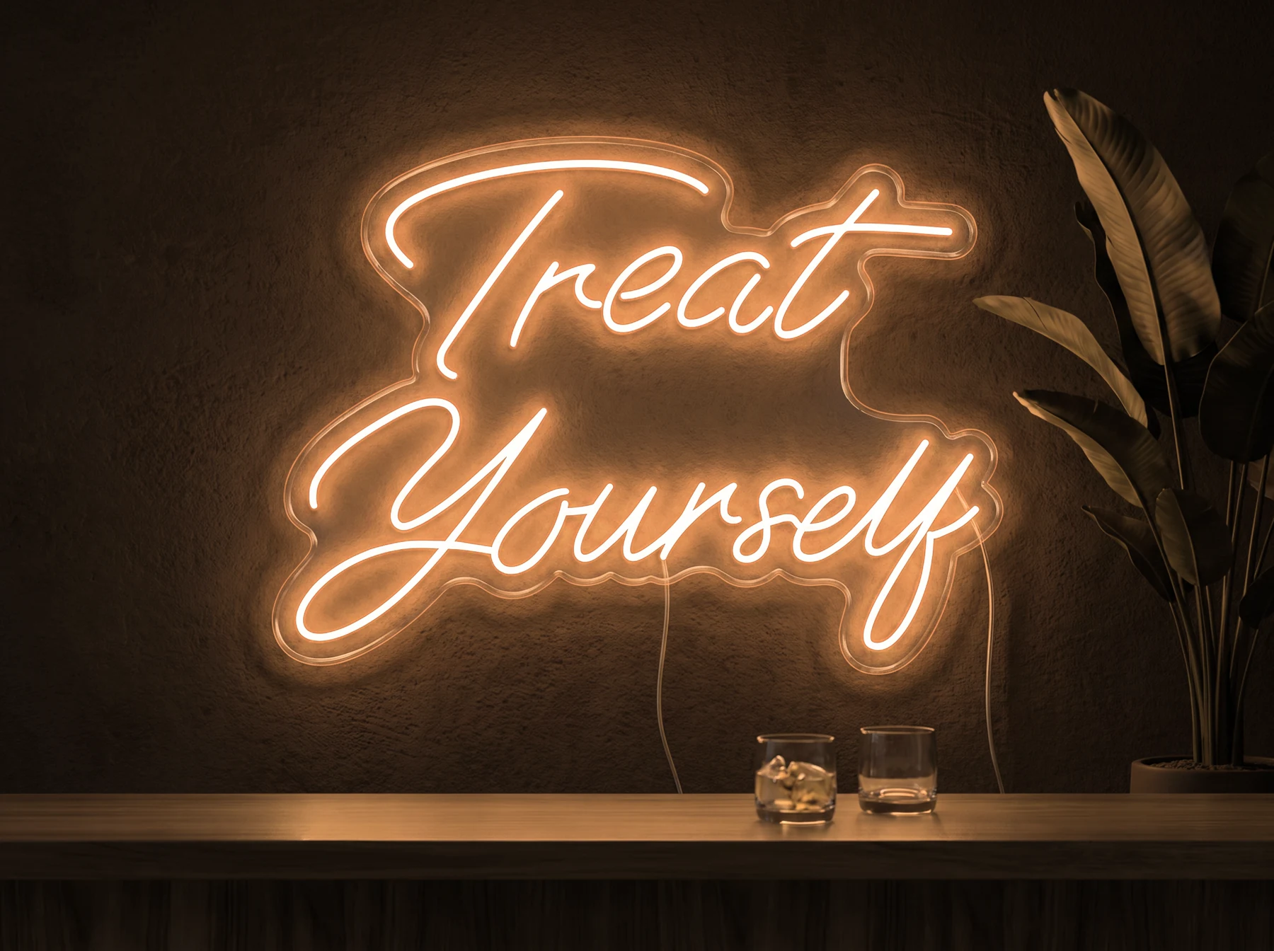 Neonskylt «Treat Yourself» i orange LED-neon, monterad på vägg