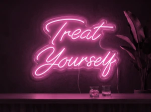 Neonskylt «Treat Yourself» i rosa LED-neon, monterad på vägg