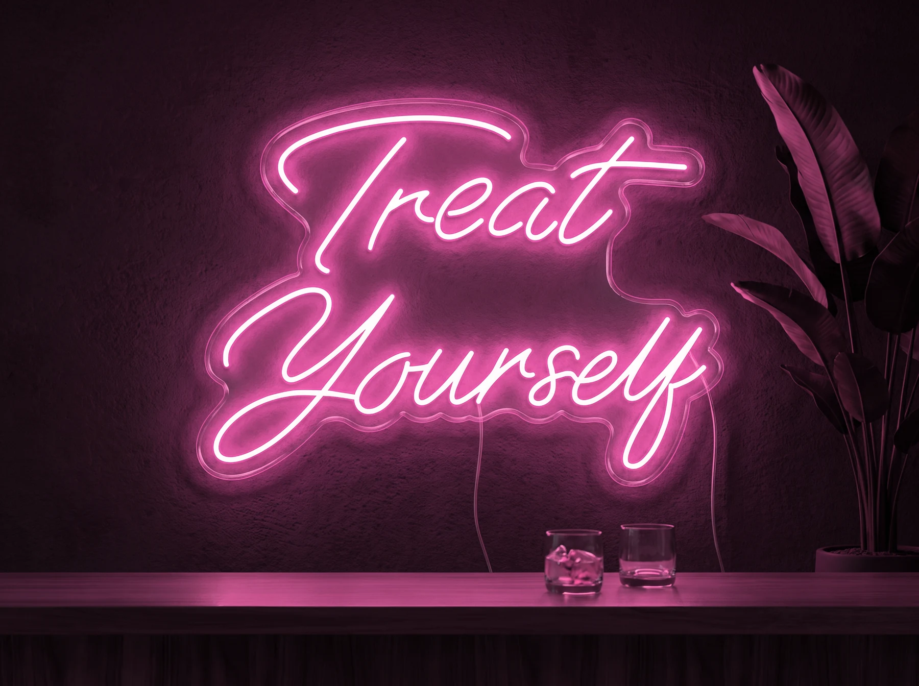 Neonskylt «Treat Yourself» i rosa LED-neon, monterad på vägg