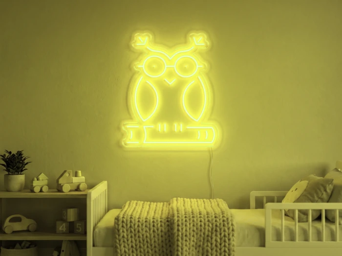 Neonskylt «Uggla» i gul LED-neon, monterad på vägg