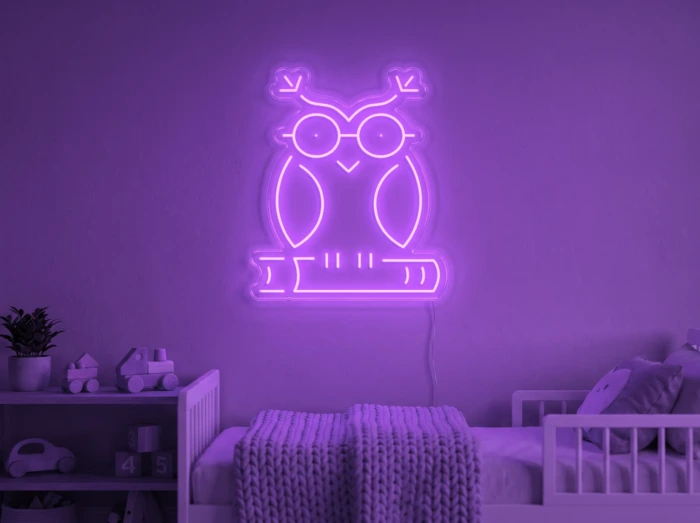 Neonskylt «Uggla» i lila LED-neon, monterad på vägg