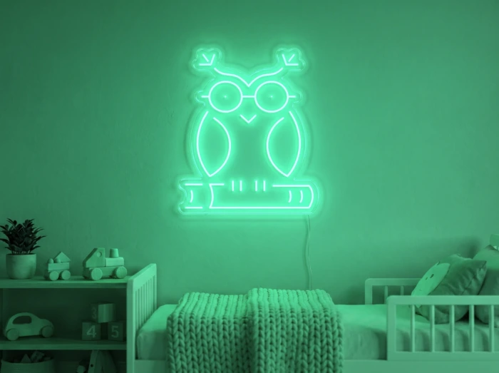 Neonskylt «Uggla» i mintgrön LED-neon, monterad på vägg