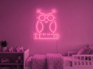 Neonskylt «Uggla» i rosa LED-neon, monterad på vägg