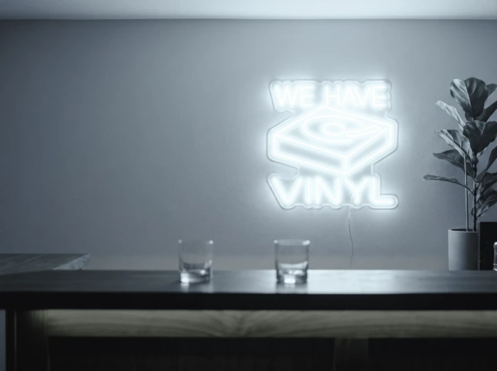 Neonskylt «We Have Vinyl» i iskall vit LED-neon, monterad på vägg