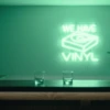 Neonskylt «We Have Vinyl» i mintgrön LED-neon, monterad på vägg