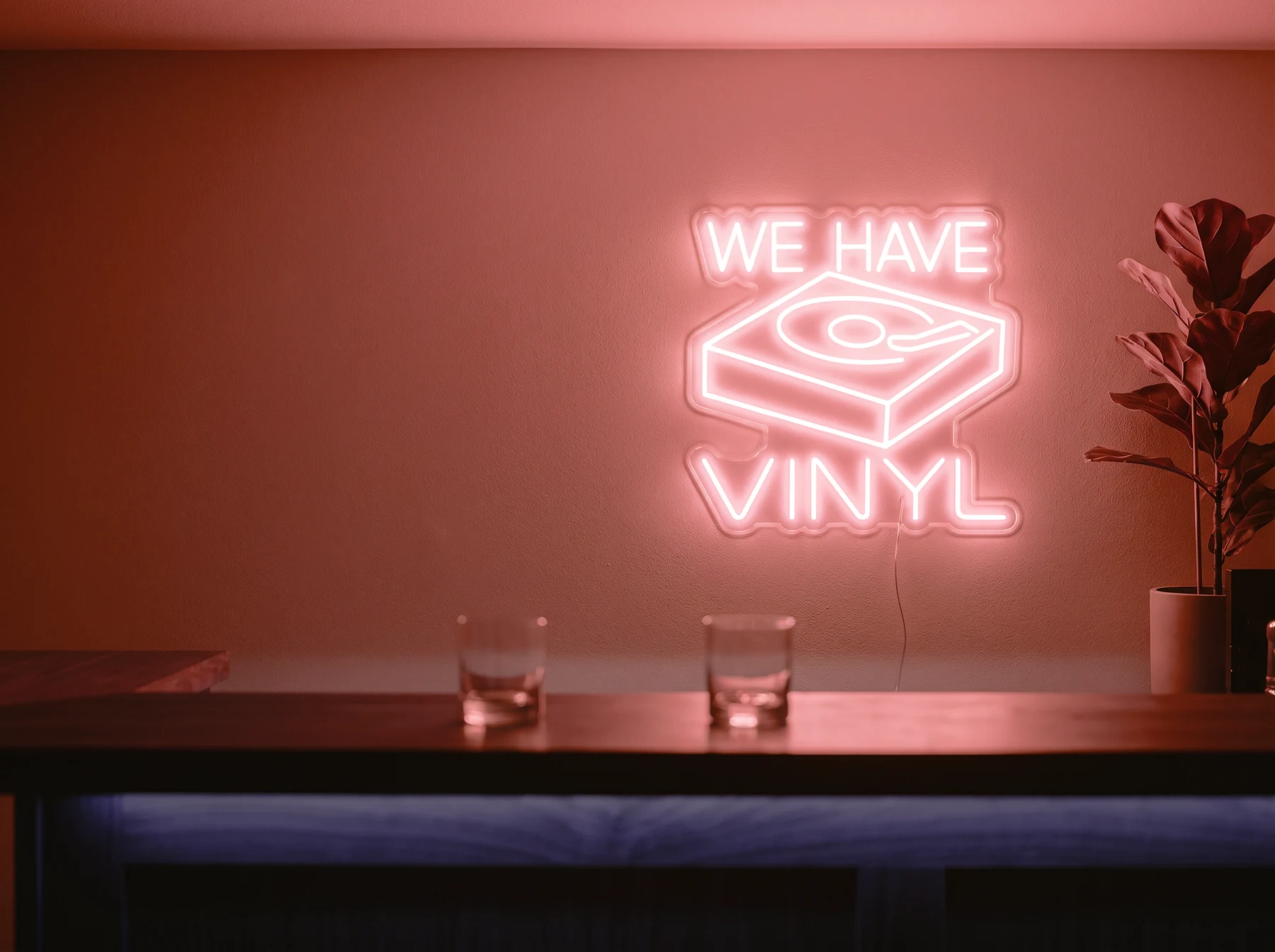 Neonskylt «We Have Vinyl» i röd LED-neon, monterad på vägg