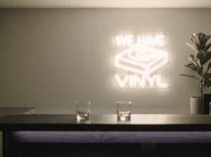 Neonskylt «We Have Vinyl» i varmvit LED-neon, monterad på vägg
