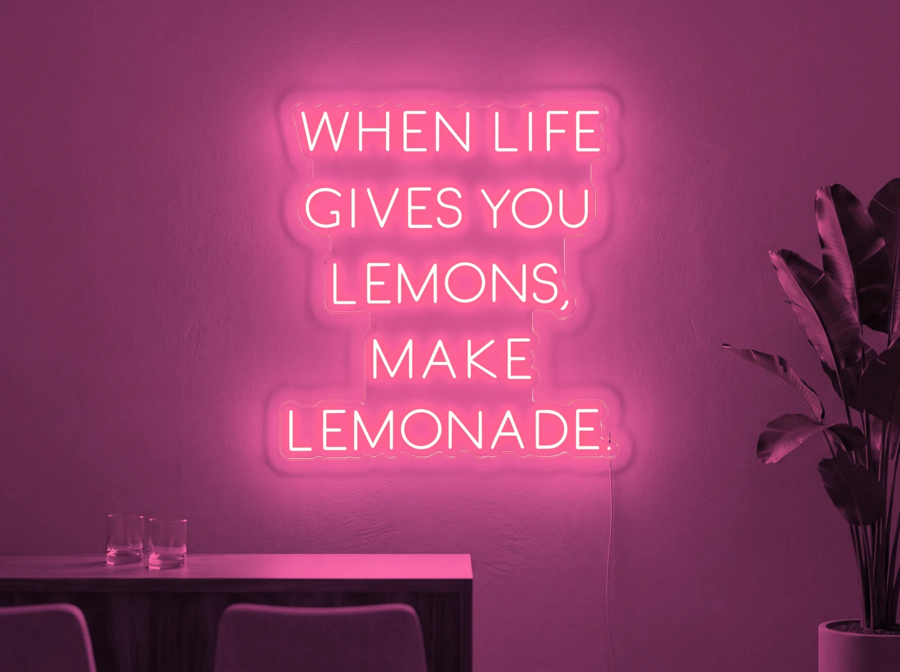 Neonskylt «When Life Gives You Lemons» i rosa LED-neon, monterad på vägg