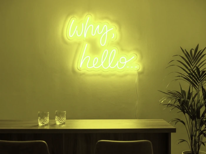 Neonskylt «Why Hello» i gul LED-neon, monterad på vägg