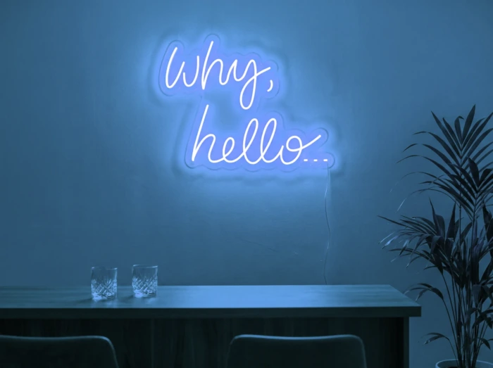 Neonskylt «Why Hello» i isblå LED-neon, monterad på vägg