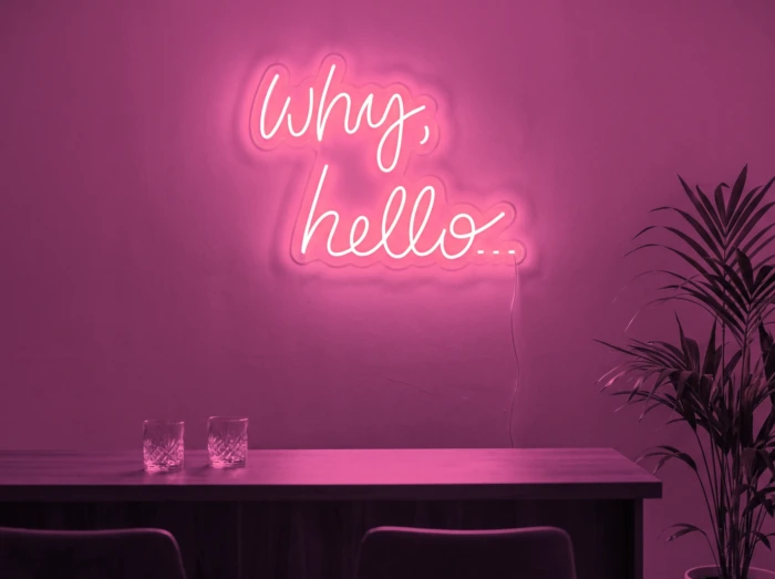 Neonskylt «Why Hello» i rosa LED-neon, monterad på vägg