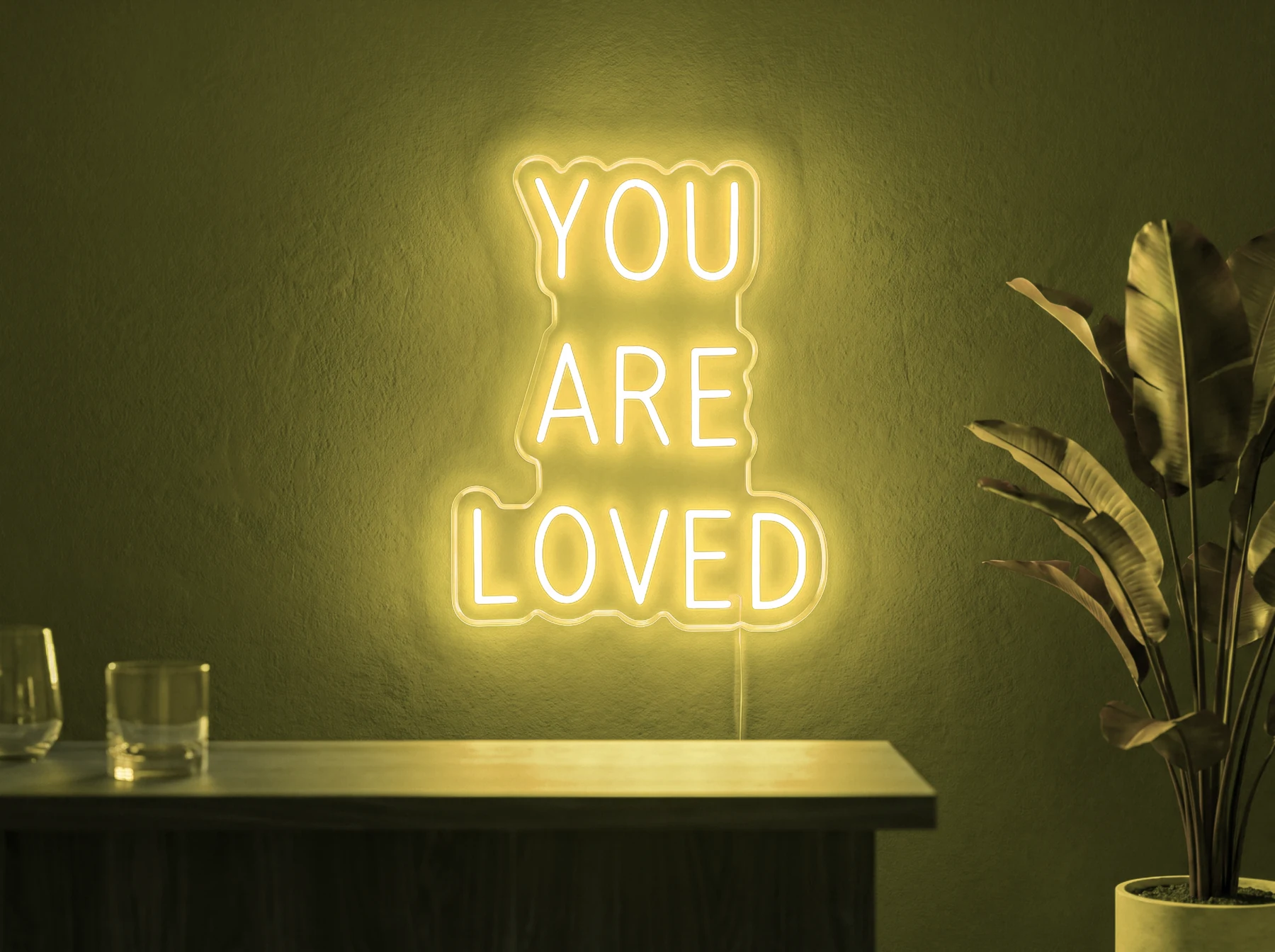 Neonskylt «You Are Loved» i gul LED-neon, monterad på vägg
