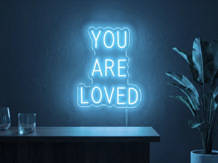Neonskylt «You Are Loved» i isblå LED-neon, monterad på vägg