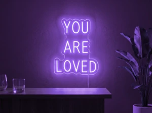 Neonskylt «You Are Loved» i lila LED-neon, monterad på vägg