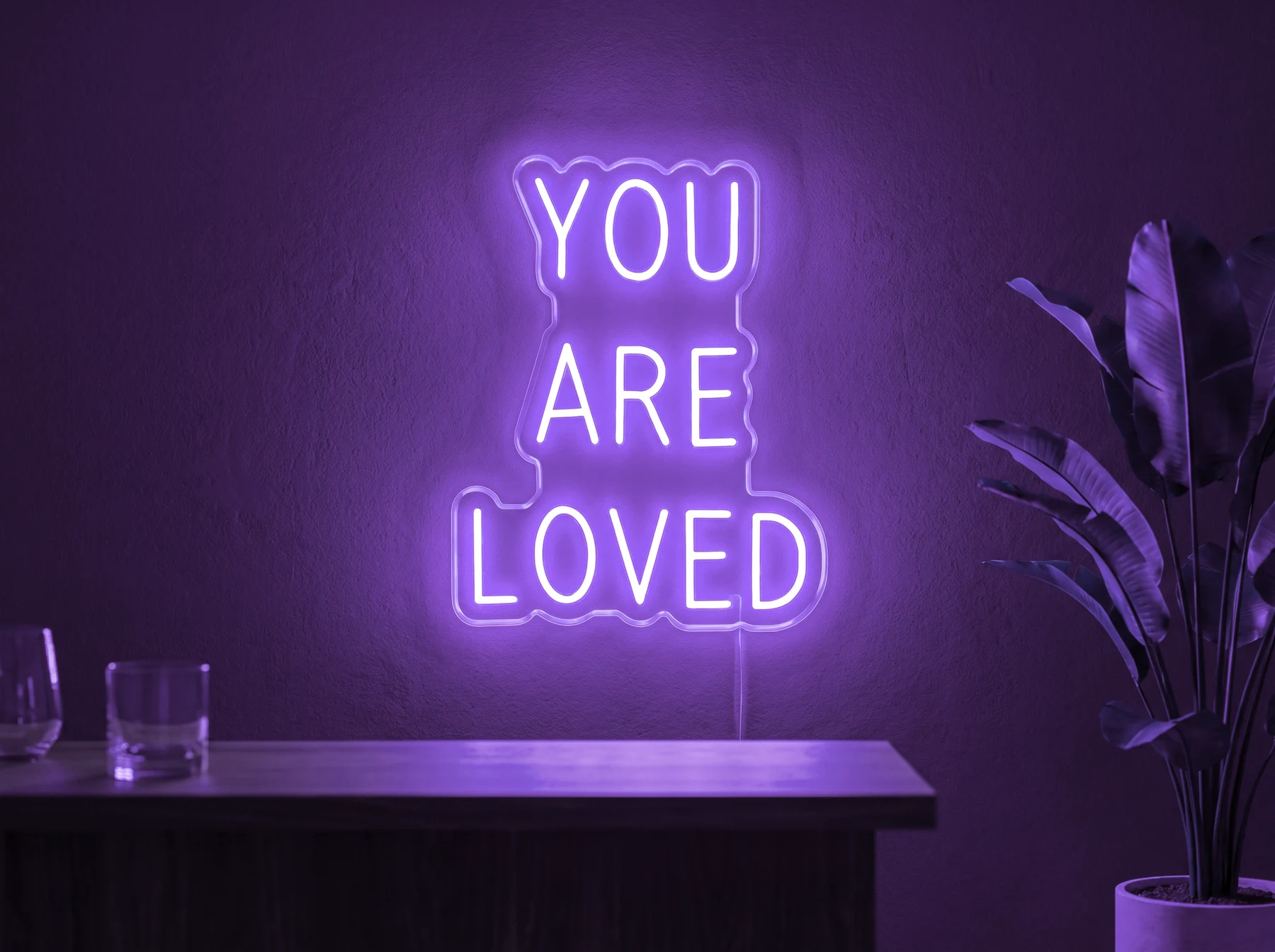 Neonskylt «You Are Loved» i lila LED-neon, monterad på vägg