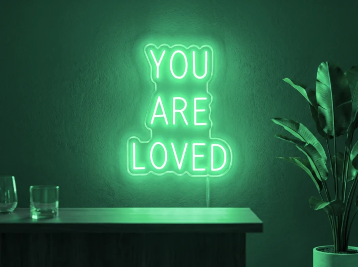 Neonskylt «You Are Loved» i mintgrön LED-neon, monterad på vägg