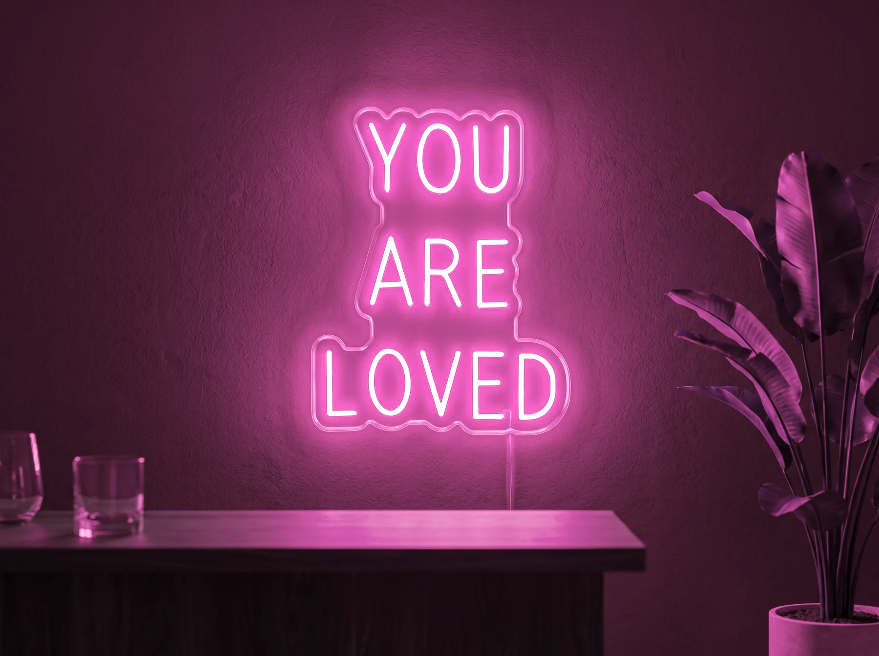 Neonskylt «You Are Loved» i rosa LED-neon, monterad på vägg