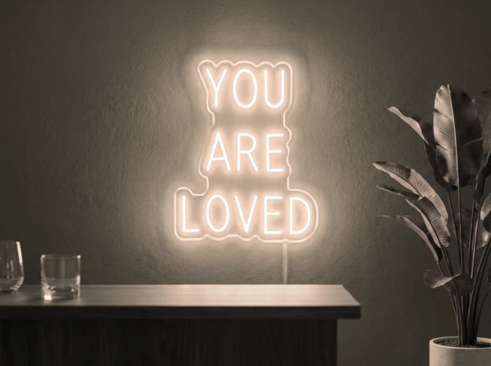 Neonskylt «You Are Loved» i varmvit LED-neon, monterad på vägg