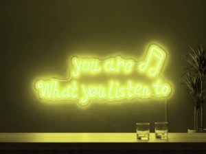 Neonskylt «You Are What You Listen To» i gul LED-neon, monterad på vägg