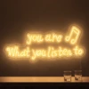 Neonskylt «You Are What You Listen To» i orange LED-neon, monterad på vägg