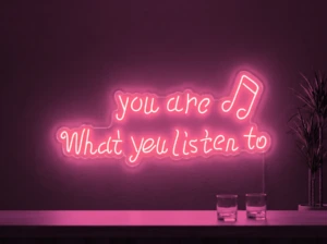 Neonskylt «You Are What You Listen To» i rosa LED-neon, monterad på vägg