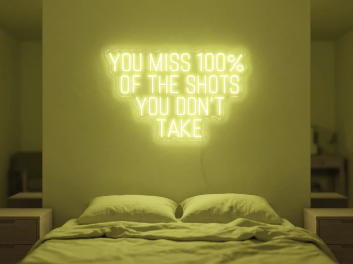 Neonskylt «You Miss 100% Of The Shots» i gul LED-neon, monterad på vägg