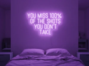 Neonskylt «You Miss 100% Of The Shots» i lila LED-neon, monterad på vägg