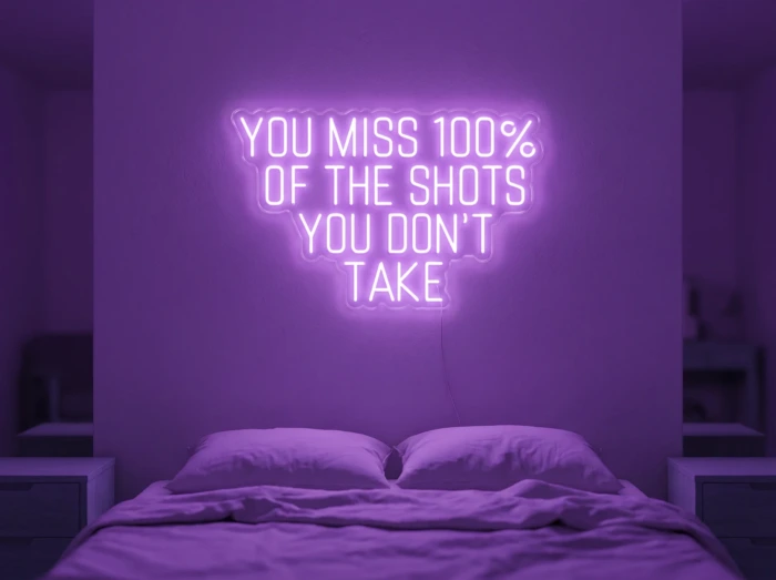 Neonskylt «You Miss 100% Of The Shots» i lila LED-neon, monterad på vägg