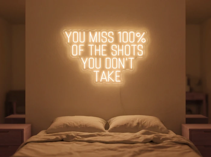 Neonskylt «You Miss 100% Of The Shots» i orange LED-neon, monterad på vägg