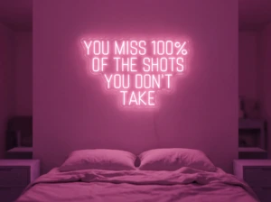 Neonskylt «You Miss 100% Of The Shots» i rosa LED-neon, monterad på vägg