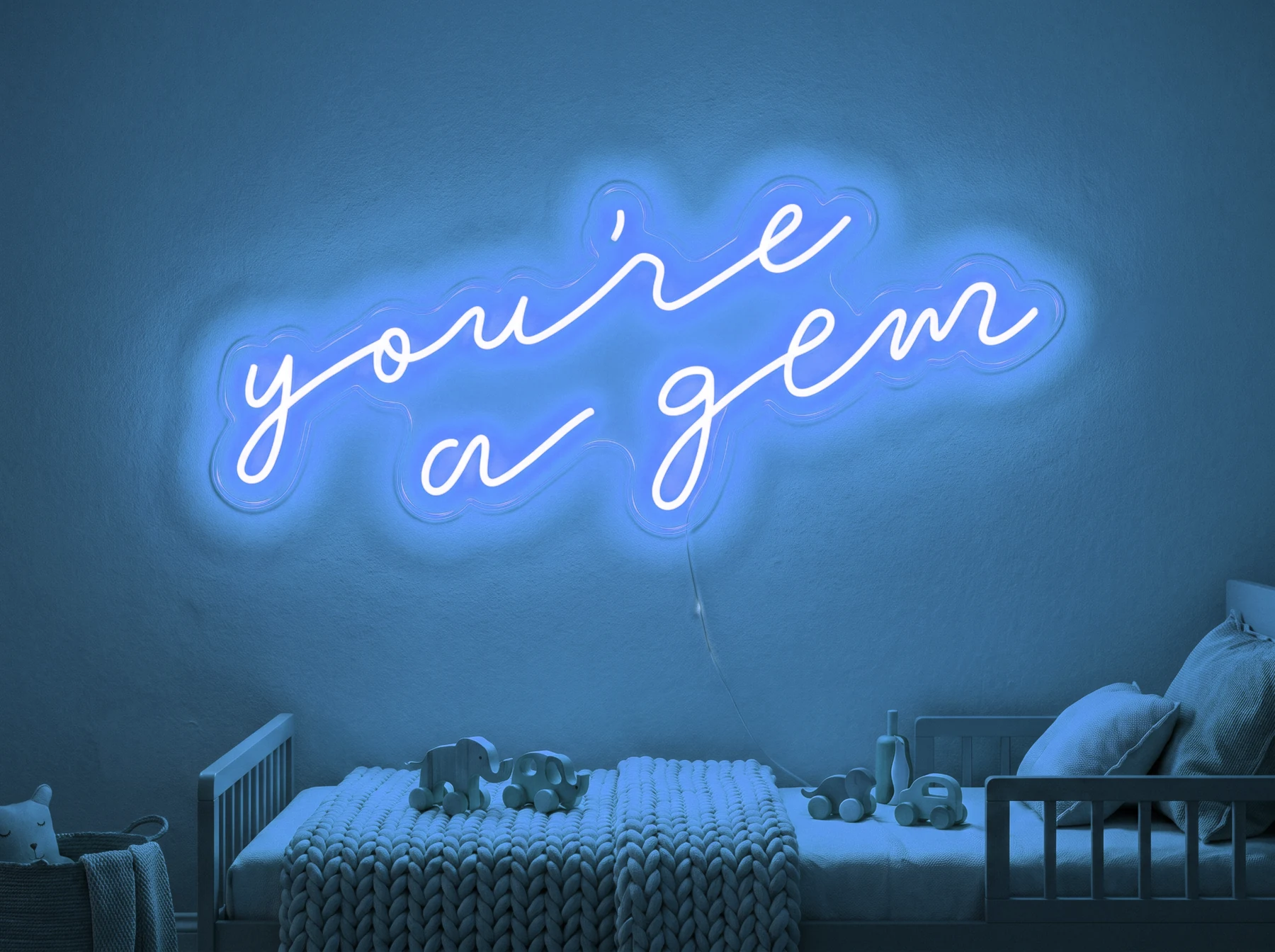Neonskylt «You’re A Gem» i isblå LED-neon, monterad på vägg