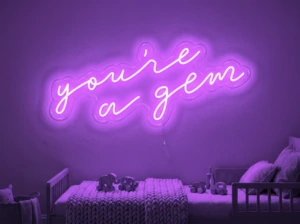 Neonskylt «You’re A Gem» i lila LED-neon, monterad på vägg