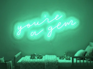Neonskylt «You’re A Gem» i mintgrön LED-neon, monterad på vägg