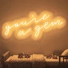 Neonskylt «You’re A Gem» i orange LED-neon, monterad på vägg