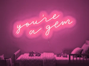 Neonskylt «You’re A Gem» i rosa LED-neon, monterad på vägg
