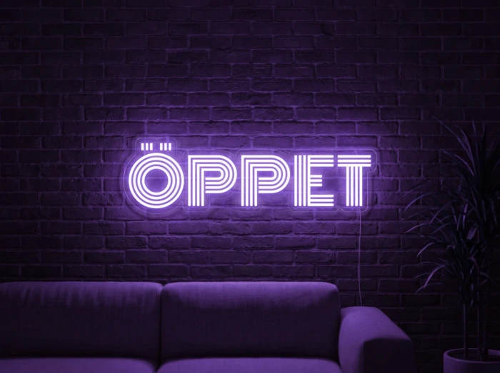 Neonskylt «ÖPPET» i lila LED-neon, monterad på vägg