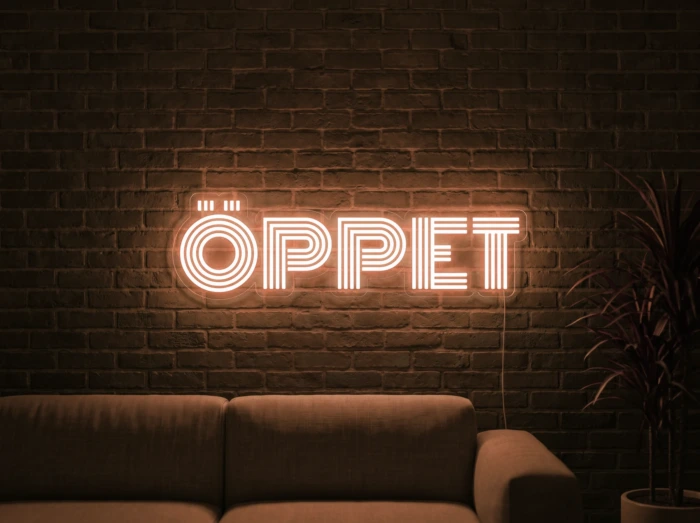 Neonskylt «ÖPPET» i orange LED-neon, monterad på vägg