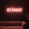 Neonskylt «STÄNGT» i röd LED-neon, monterad på vägg